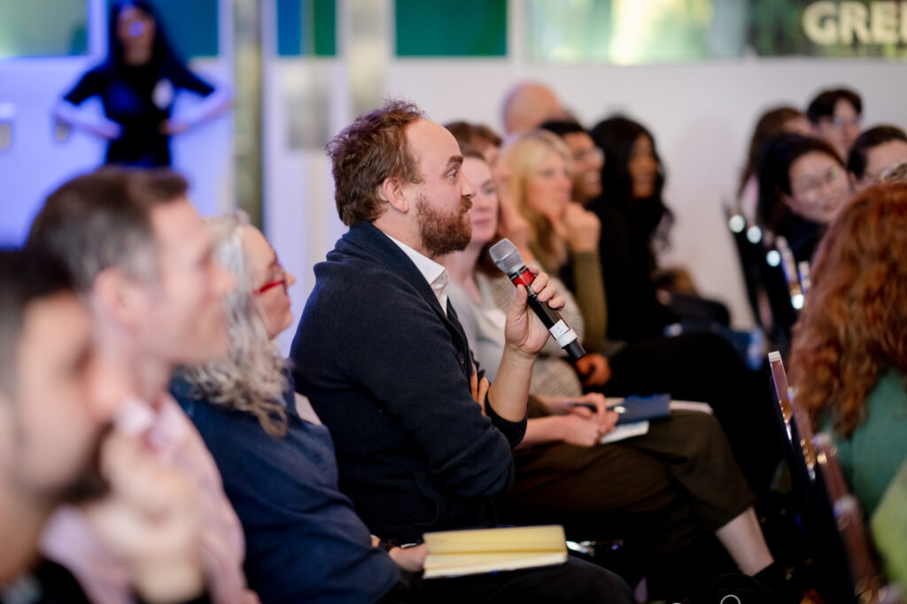 An attendee contributes a question during a session at the MACC Hub conference.
