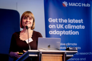 A MACC Hub speaker presents a session at the front stage of the main room during the MACC Hub conference.